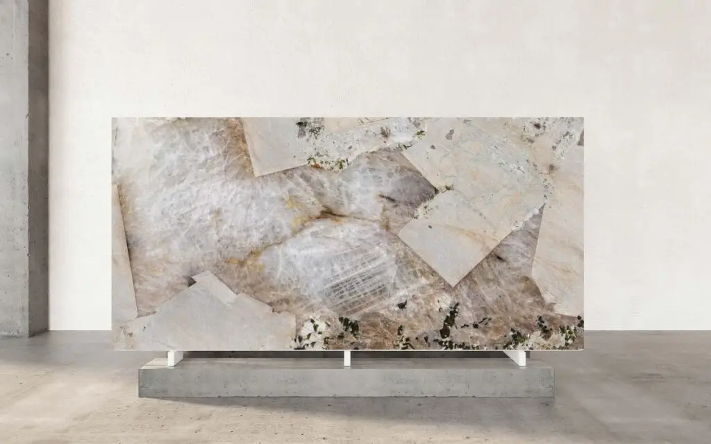 Alpinus Quartzite is a breathtaking natural stone that captivates with its intricate patterns and rich palette. Its surface showcases a harmonious blend of creamy whites, warm beiges, and earthy browns, interspersed with striking veins of dark gray and subtle hints of green. The crystalline structure of the stone creates a dynamic interplay of translucency and opacity, evoking the raw beauty of nature. Each slab is a unique masterpiece, with linear striations and fragmented patterns that add depth and character, making it a perfect choice for those seeking a statement piece. Beyond its visual allure, Alpinus Quartzite is celebrated for its durability and versatility. Its robust composition makes it ideal for high-traffic areas such as kitchen countertops, feature walls where both style and resilience are paramount. The polished finish enhances its natural luster, reflecting light to create a sense of spaciousness and sophistication. Whether used in modern minimalist designs or paired with rustic elements, Alpinus transforms any space into a showcase of timeless elegance and natural artistry.
