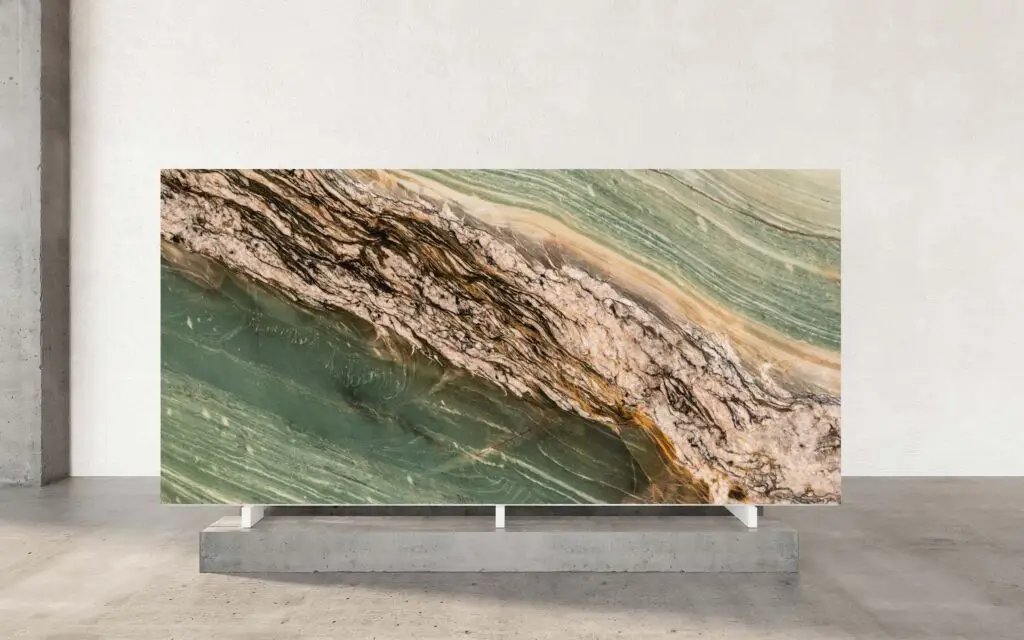 Cristallo Maestro captivates with its rich green base, reminiscent of emerald landscapes. Dynamic brown and gold veins sweep diagonally across the stone, lending an artistic flair and unique character to every slab. The interplay of colors evokes images of sunlight filtering through an ancient forest, imbuing each surface with a sense of depth and tranquility. Striking and refined, this quartzite elevates interiors with a blend of natural beauty and luxury. Its bold colors and dramatic veining make it an ideal choice for statement pieces in any sophisticated setting. Chosen for kitchen islands, feature walls, or vanities, Cristallo Maestro transforms functional spaces into exquisite works of art.